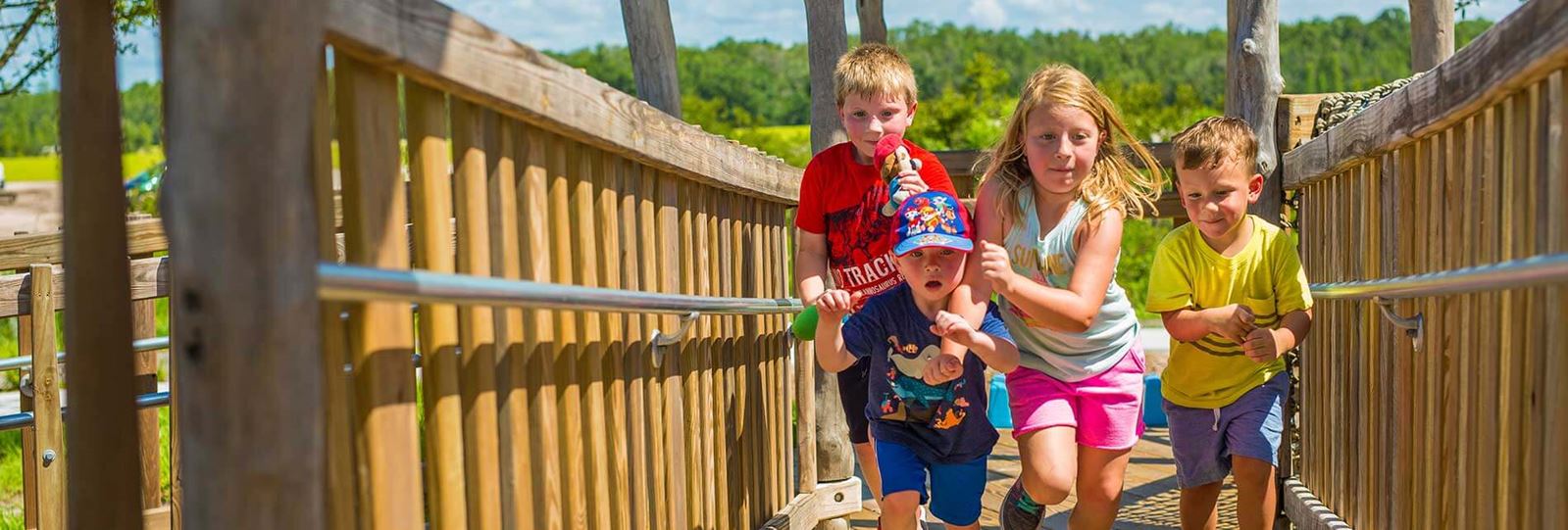 Kids running and playing on boardwalk amenity at a playground in Bexley.