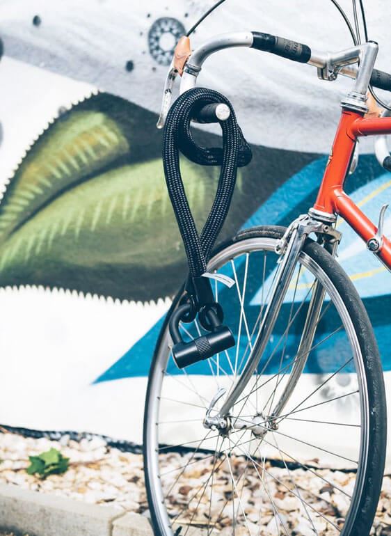 Bicycle resting along wall mural.
