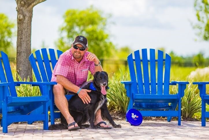 Man with dog relaxing on blue chairs